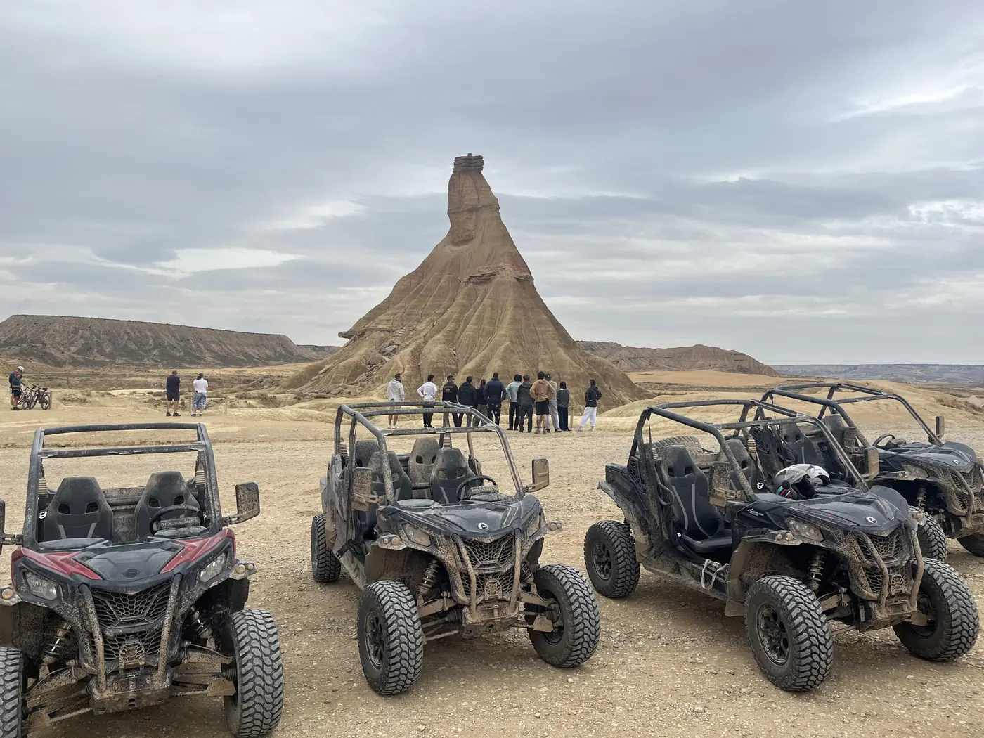 Buggies off-road aparcados frente a Castildetierra mientras un grupo de empresa contempla el paisaje de las Bardenas Reales